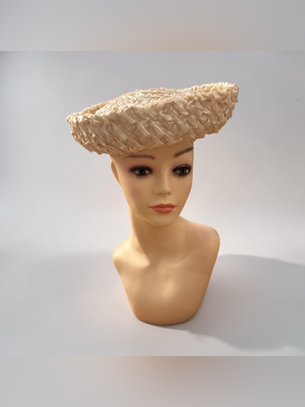 A vintage 1950s or 1960s Breton or platter hat made of woven ivory raffia straw
